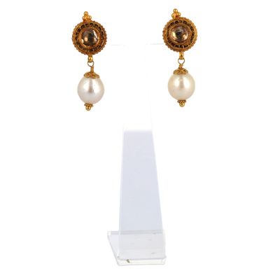 gros plan d'une paire de boucles d'oreilles sur une surface blanche