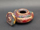 a small vase with a lid sitting on a table