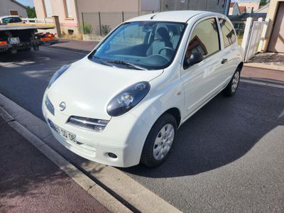 une petite voiture blanche garée sur le bord de la rue
