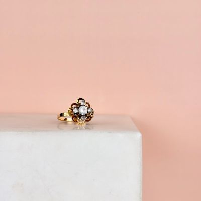 un gros plan d'une bague en or ornée d'une fleur posée sur un bloc