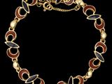 un bracelet en or orné de perles en émail rouge, noir et blanc