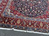 a large oriental rug on the ground with a cat sitting on it