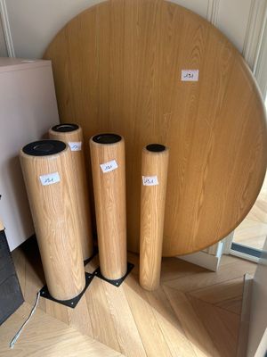 three wooden cylinders sitting on the floor next to a round table