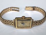 l'image d'une montre-bracelet en or entourée d'une chaîne