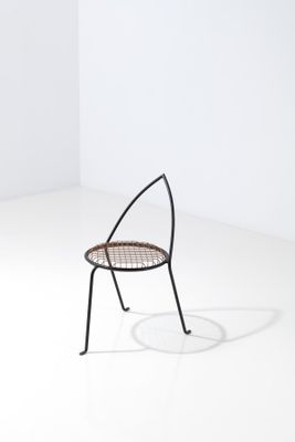 une image représentant une chaise dans une pièce blanche, avec une ombre sur le sol