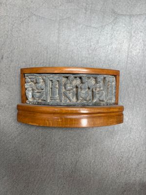 une image représentant une plaque en bois ornée d'un motif sculpté
