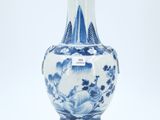 a blue and white vase sitting on a white surface
