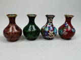 three vases with different designs are lined up on a white surface