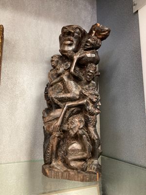 une statue représentant une femme tenant un enfant dans ses bras, posée sur une étagère en verre