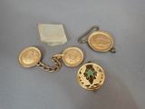 two gold cuff watches and a gold keychain with a cross on it