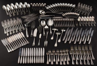 a large collection of silverware on a black table