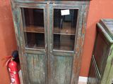 une vieille armoire en bois avec des portes vitrées et un extincteur
