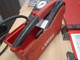 une boîte rouge contenant un outil, posée sur une table