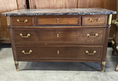 an image of a wooden dresser with marble top in a room