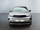 the front view of a silver suv parked in a showroom