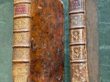 two old books sitting on a table next to each other