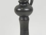 un vase noir posé sur une surface blanche