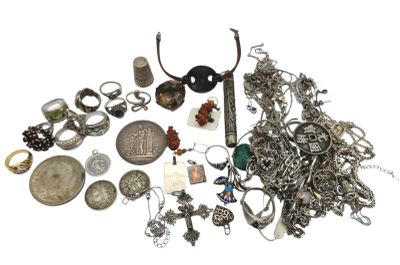 a pile of silver jewelry on a white surface