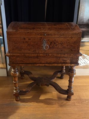 a small wooden box on a stand on a hard wood floor