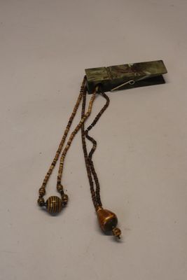 une photo d'un collier avec des perles posé sur une table blanche
