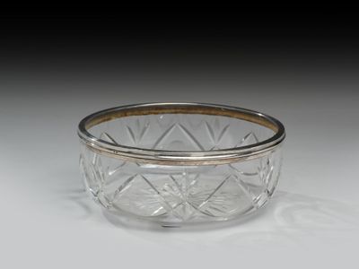 un gros plan d'un bol en verre posé sur une surface blanche