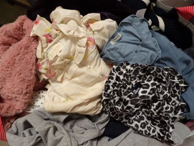 un tas de vêtements dans une valise posée par terre