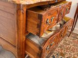 a wooden dresser with a marble top in a living room
