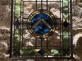 the stained glass window is hanging on the wall in the room