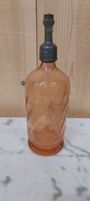 a glass bottle with a black top sitting on a table