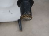 a close up of a black pipe with rust on it