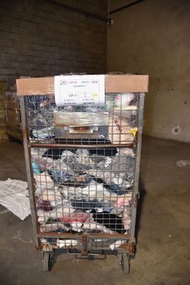 a cart full of garbage in a warehouse with a sign on it