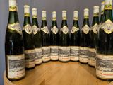 a lot of bottles of wine sitting on a wooden table