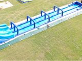 a blue water slide in the middle of a green field