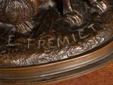 a bronze statue of a dog and a cat on a table
