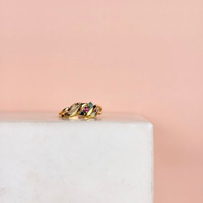 un gros plan d'une bague en or posée sur un bloc de marbre