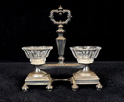 paire de bougeoirs plaqués argent sur un socle, sur fond noir