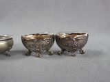 three small silver dishes sitting on top of a table next to each other