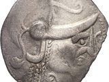 an ancient coin with a man ' s head and a hat on it