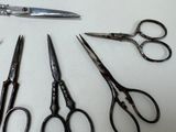 five pairs of scissors sitting on a table next to each other