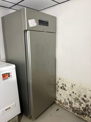 an image of a kitchen with moldy walls and a refrigerator