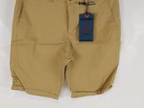 a pair of tan shorts hanging on a white wall