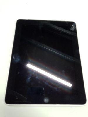 une tablette noire posée sur une table blanche