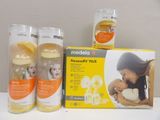 three bottles of breast milk and a box of breast milk on a table