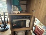 a microwave that is built into the side of a cabinet
