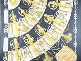 an image of a black and gold scarf with a bunch of gold items on it