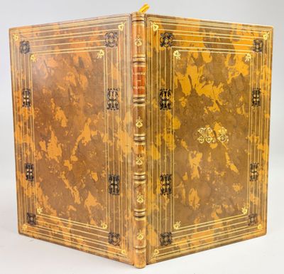 un vieux livre à la couverture dorée posé sur une surface blanche