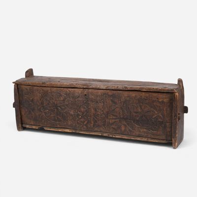 an old wooden trunk with carvings on the sides of it
