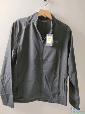 une veste grise accrochée au mur à côté d'un cintre