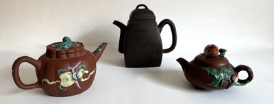 trois théières et une théière posées sur une table blanche