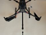 a small black drone with four propellers on a tripod